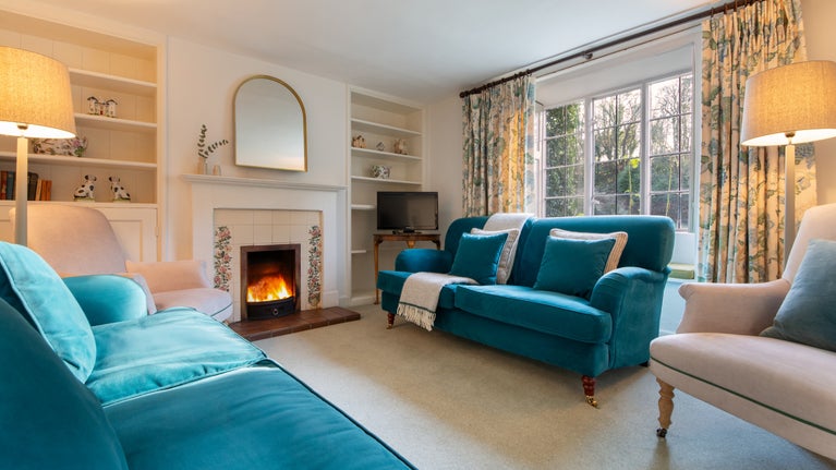The sitting room at 89 Church Lawn, with views over the front garden and the medieval church beyond, Wiltshire